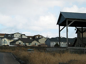 Rustic barn roof in foreground, modern residences in background